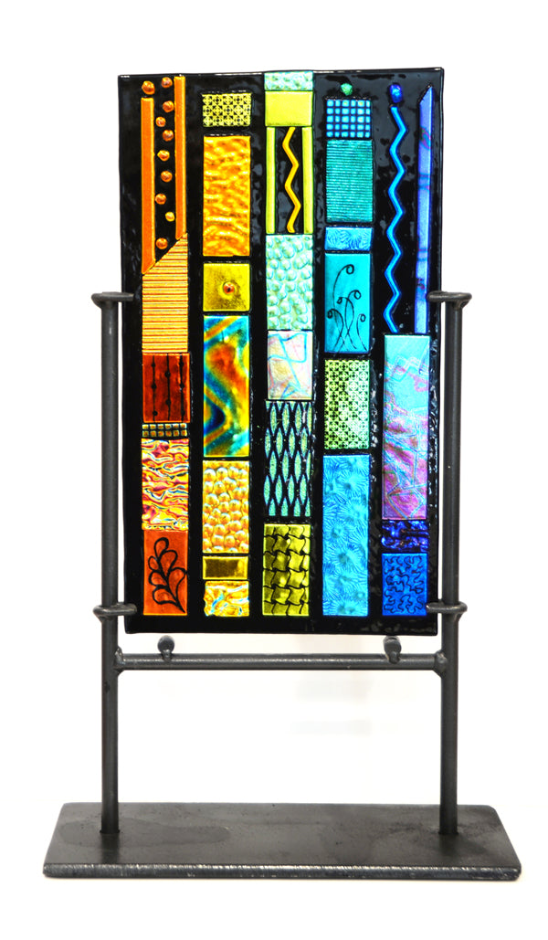Colorful stained glass panel on a stand with a white background