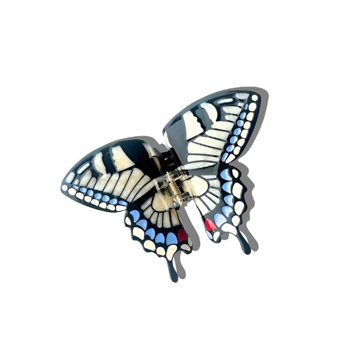 Butterfly-shaped hair clip with blue, white, and black colors on a white background