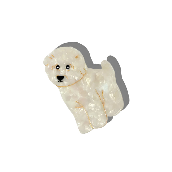 White dog-shaped hair clip with gold accents on a white background