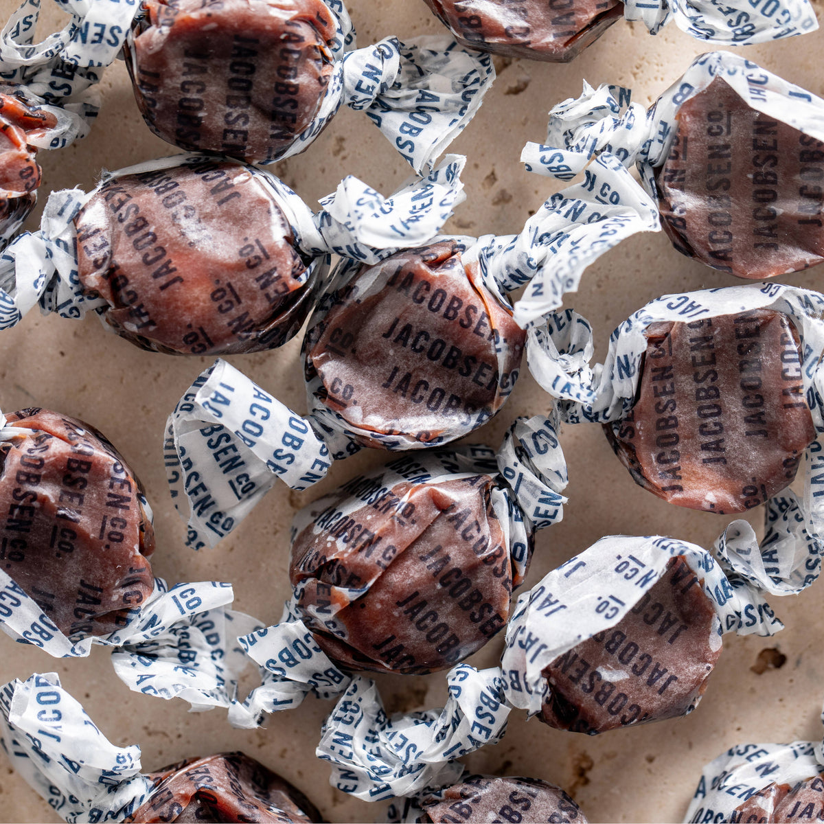 Assorted candies in paper wrappers on a cardboard surface