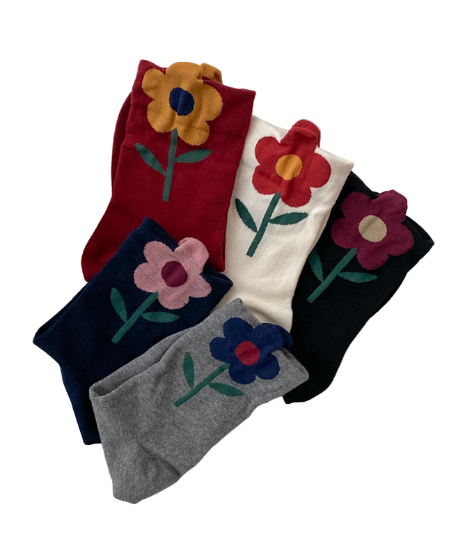 Four pairs of socks with floral designs on a white surface