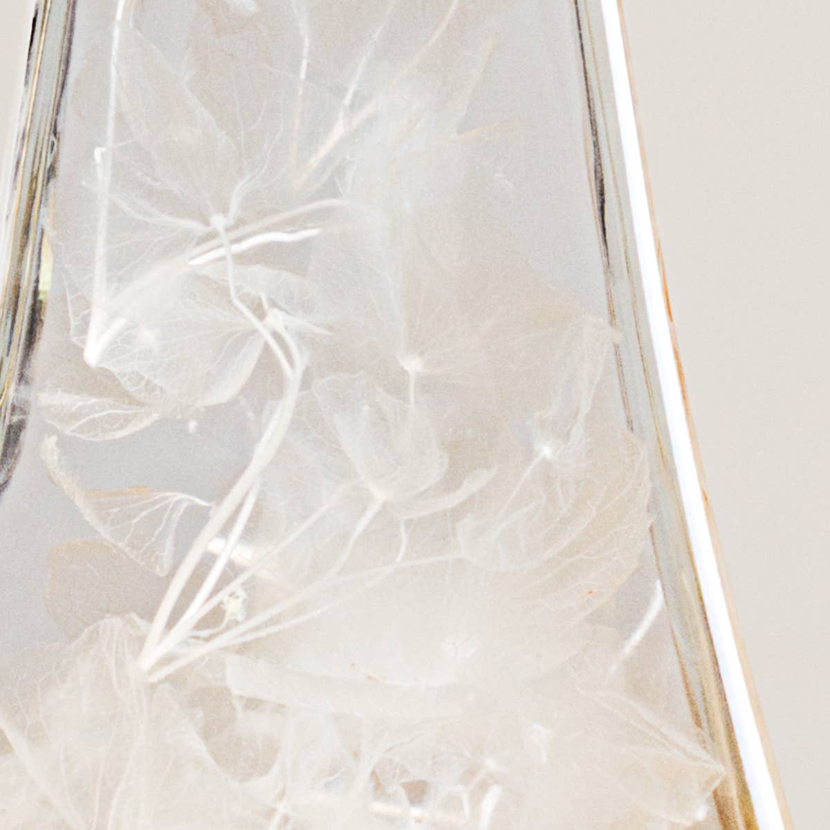 Close-up of a glass with floral etching on a white background