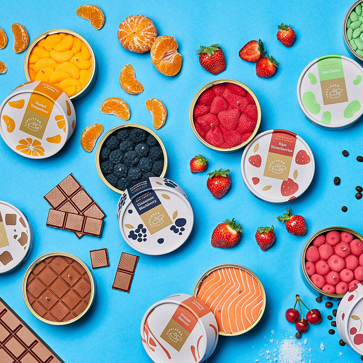 Assorted snacks including fruits, chocolates, and candy candles on a blue background