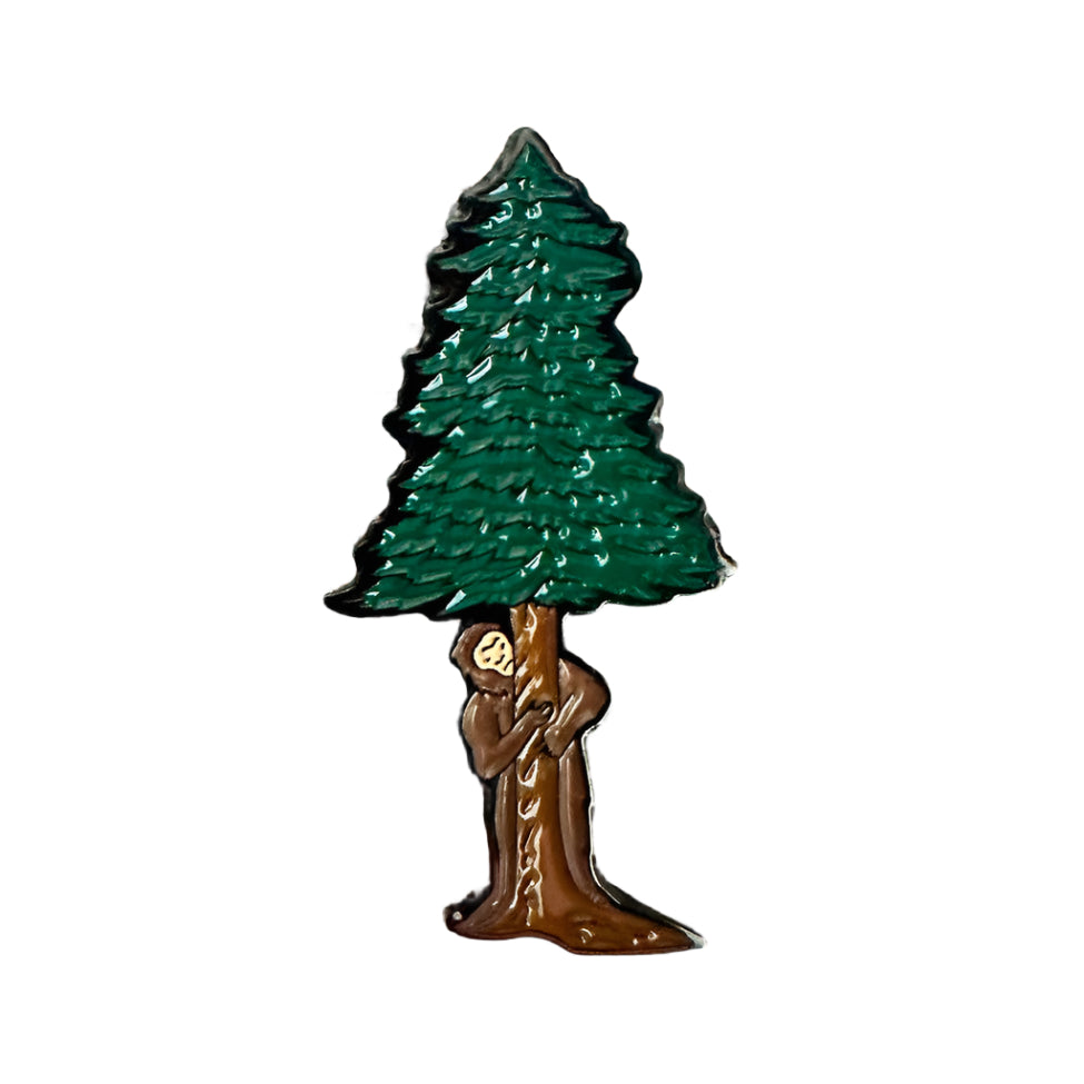 a green tree and big foot hiding behind