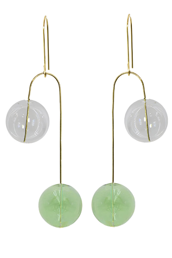 Pair of earrings with green and white spherical glass balls on gold hooks against a white background